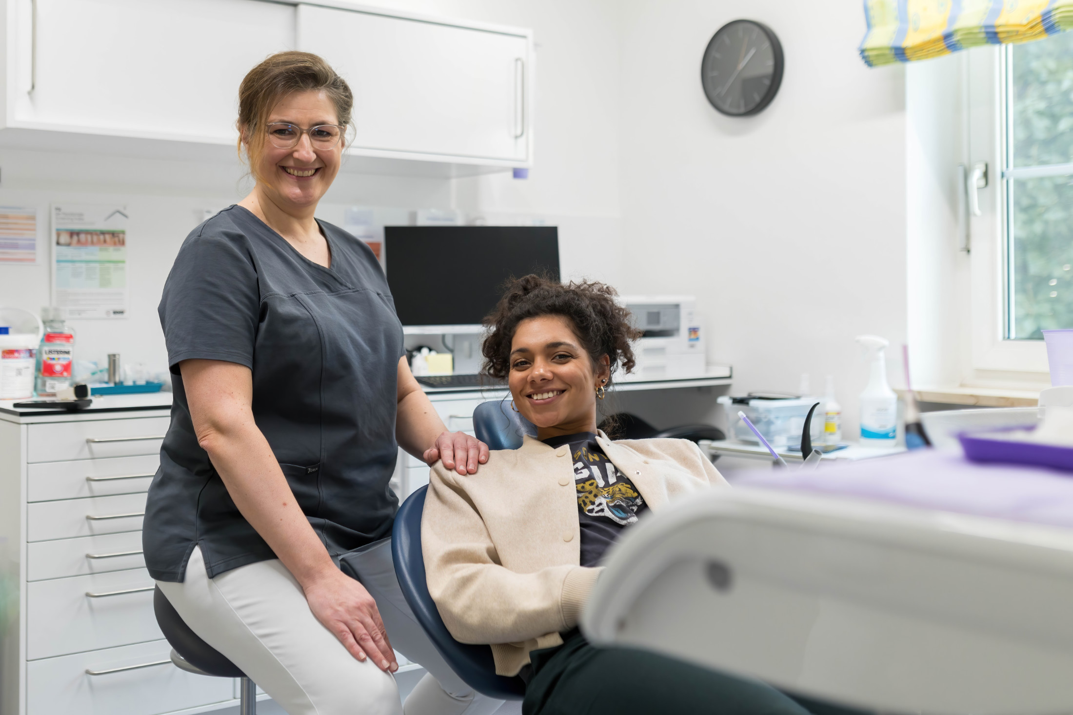 Mitarbeiterin mit Patientin auf dem Stuhl