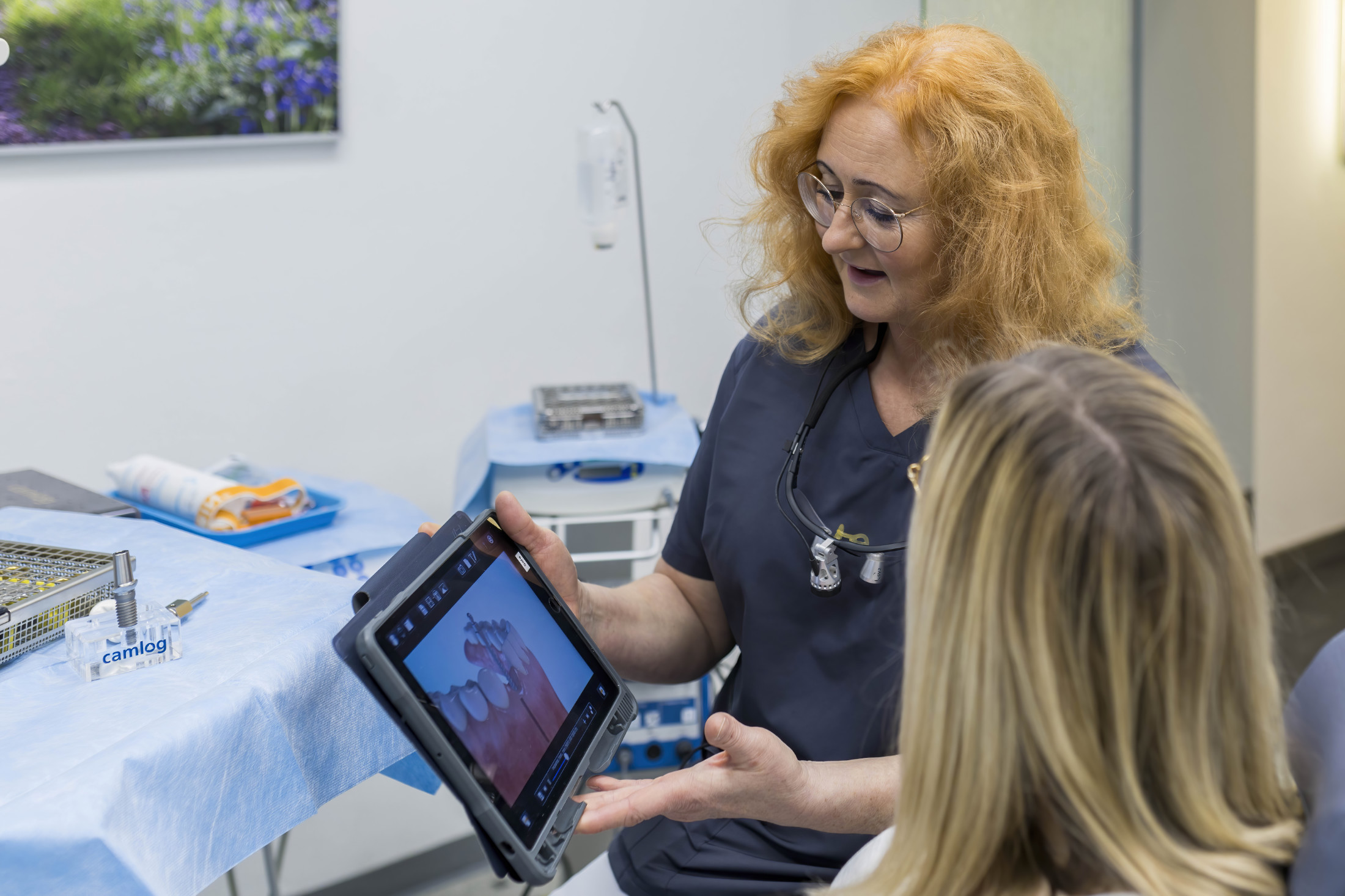 Aufklärung vor der Zahnimplantat OP – Teammitglied erklärt Patientin die nächsten Schritte